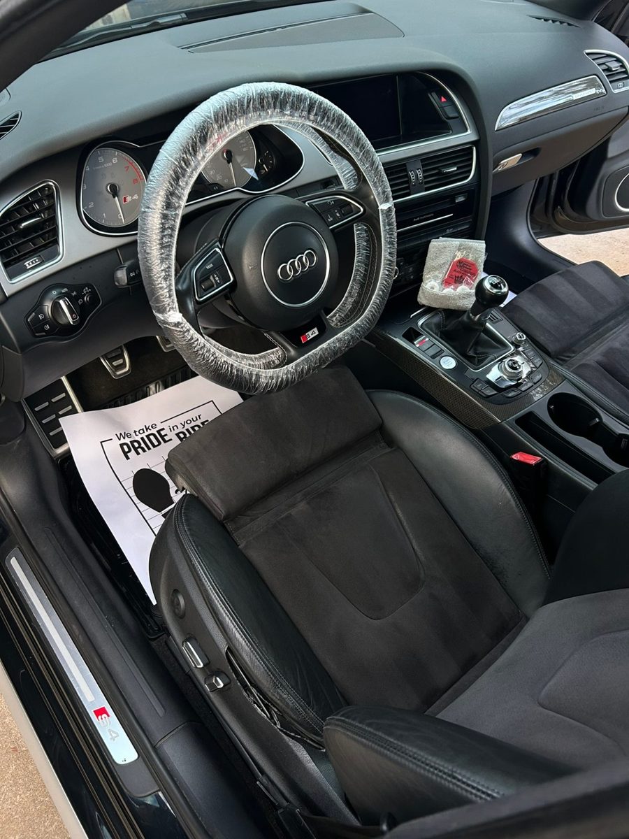 Audi S4 interior after a detail, with a covered steering wheel and a Clarity paper floor mat