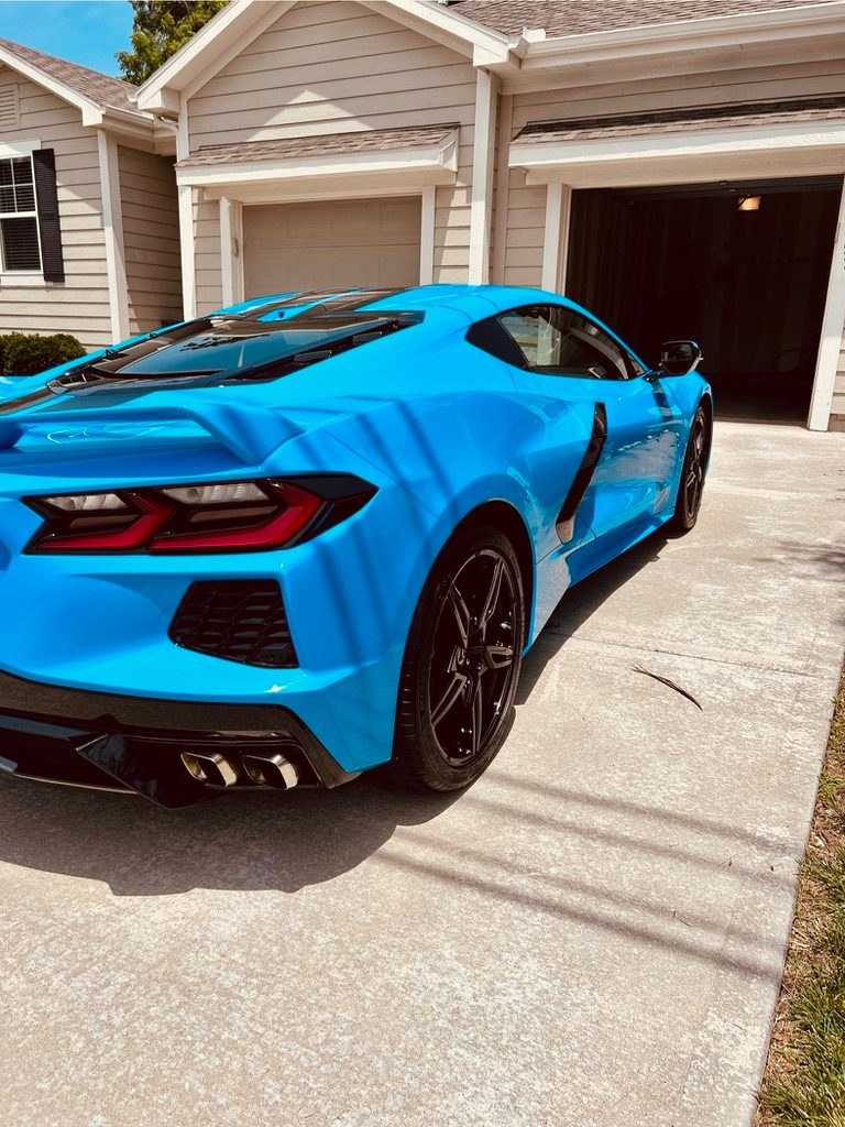 Blue Corvette with a glossy finish after a mobile exterior detail in a driveway