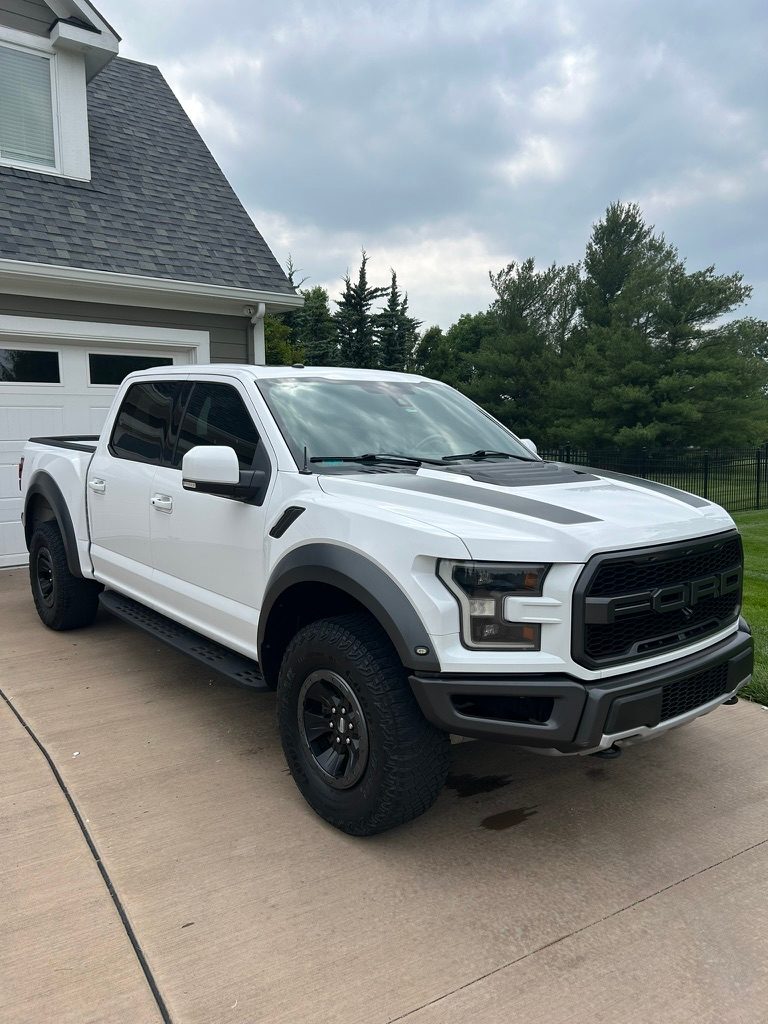 White Ford F-150 Raptor after a mobile exterior detail in a driveway