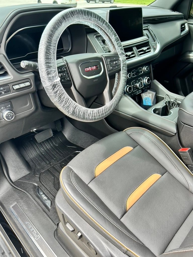 GMC Yukon AT4 leather interior after a mobile interior detail, with a covered steering wheel