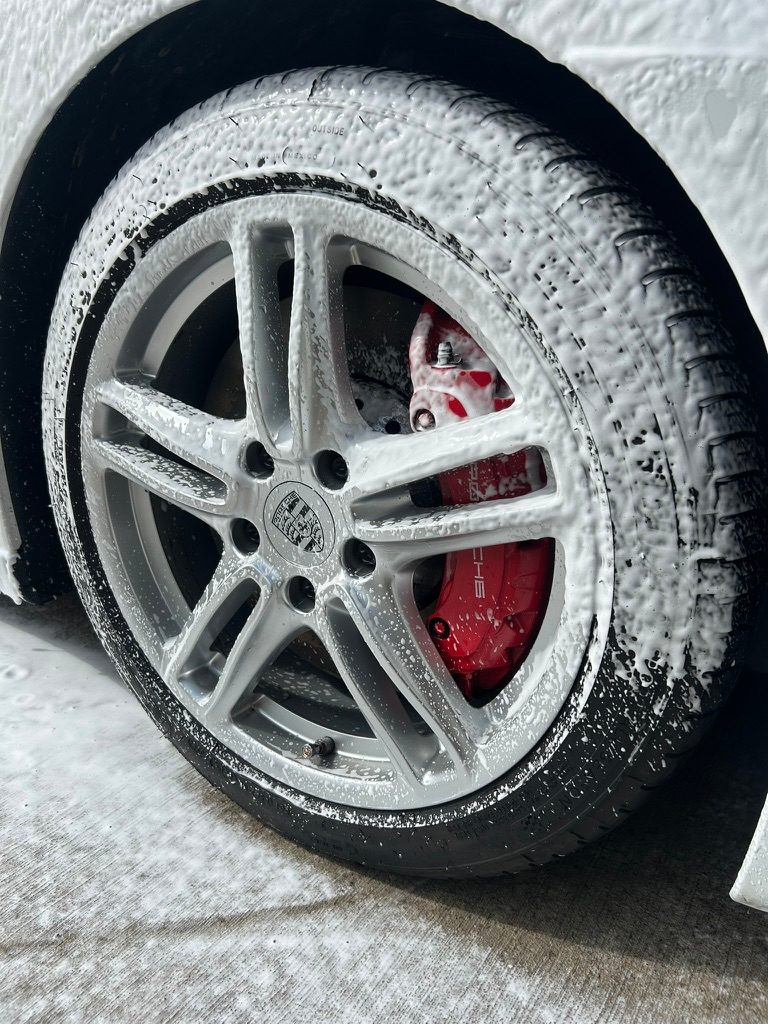 Porsche wheel covered in foam during wheel cleaning