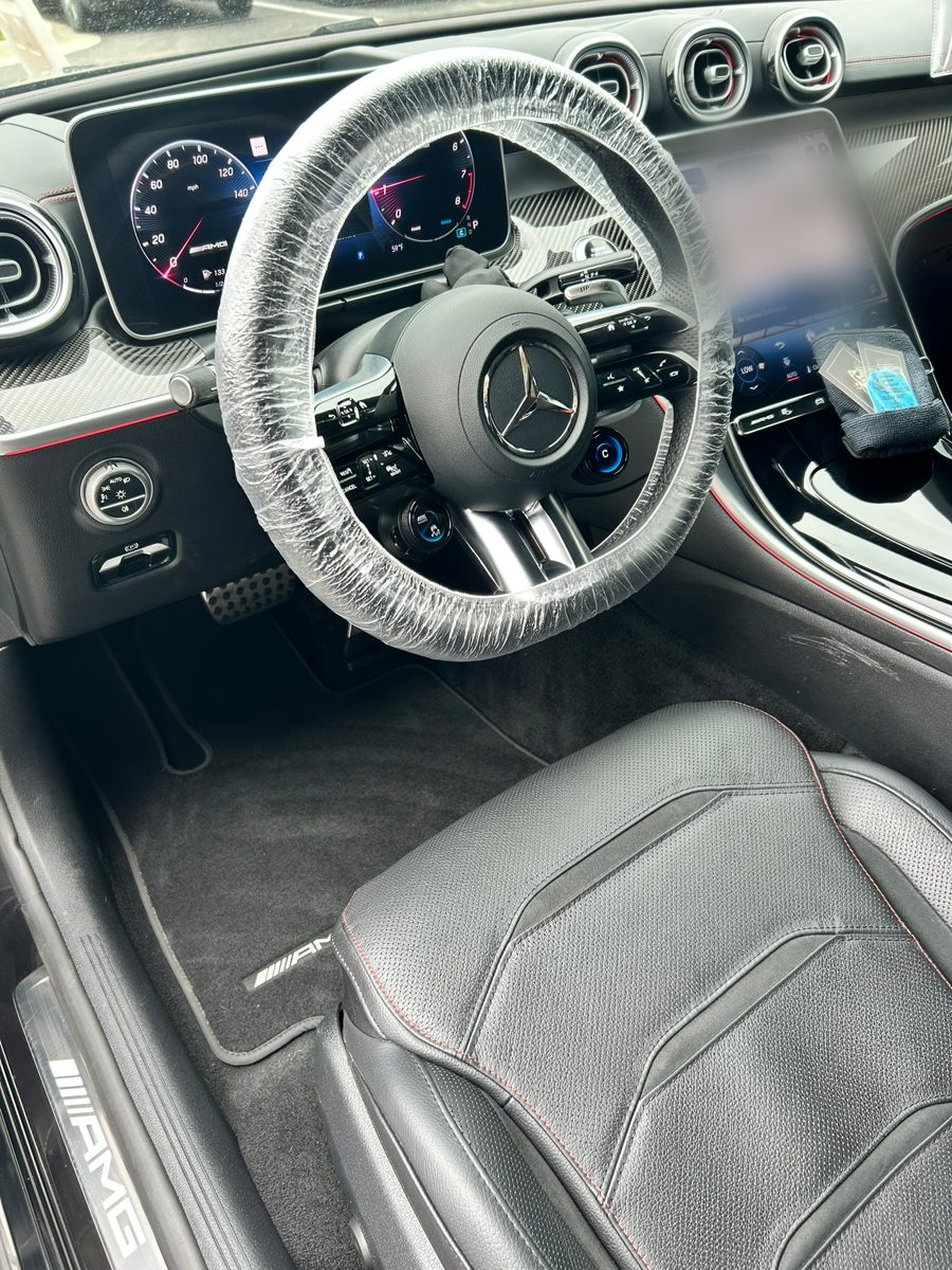 Mercedes-AMG C-Class interior with black leather seats and clean floor mats after an interior detail