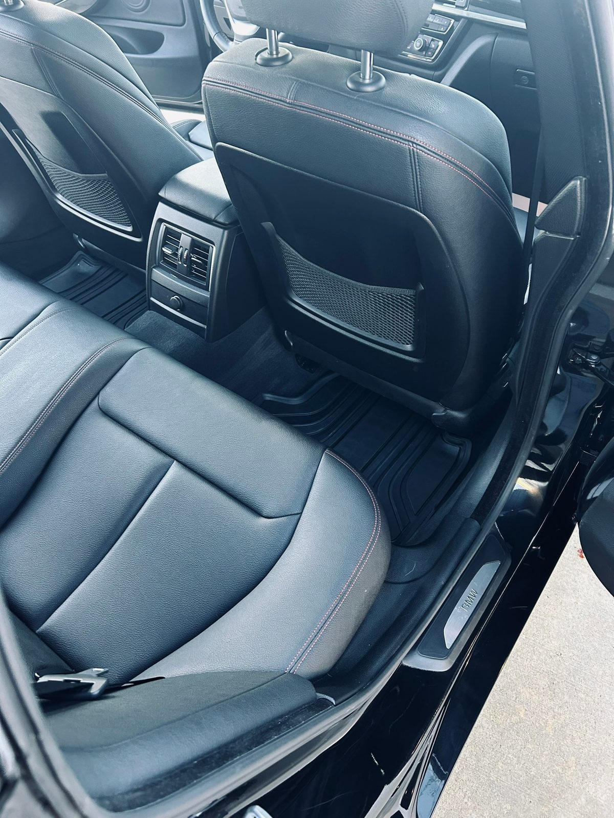 Black leather rear seats in a BMW 4 Series after an interior detail