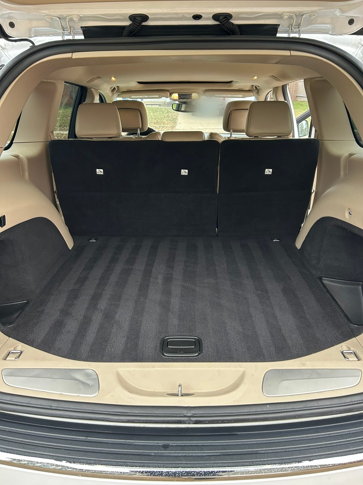 Freshly vacuumed cargo area of a white Jeep Grand Cherokee after an interior detail