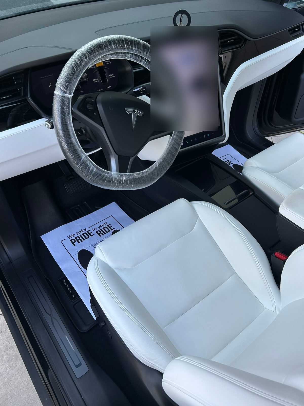 White leather front seats in a Tesla Model X after an interior detail