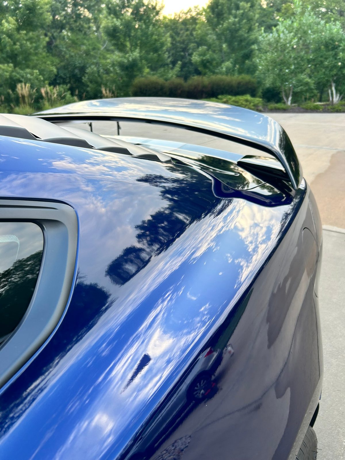 Clouds reflecting in the blue paint of a Shelby GT350 after an exterior detail