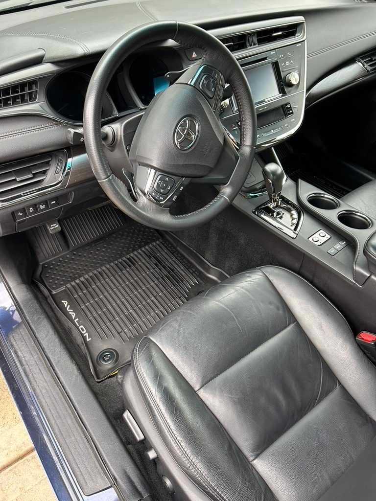 Toyota Avalon interior with black leather seats and clean all-weather mats after a detail